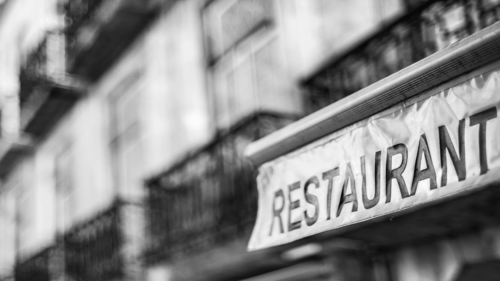 black and white closeup of the word RESTAURANT on an awning