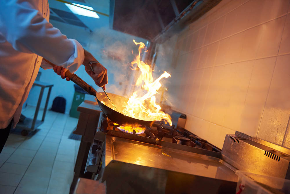 chef in hotel kitchen prepare vegetable food with fire chef in hotel kitchen prepare vegetable food with fire